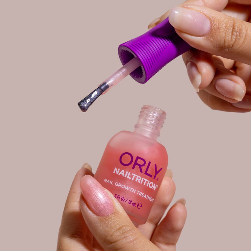 Orly Nailtrition treatment bottle with a dropper on a beige background
