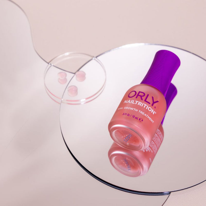 ORLY Nailtrition nail growth treatment bottle on a reflective surface